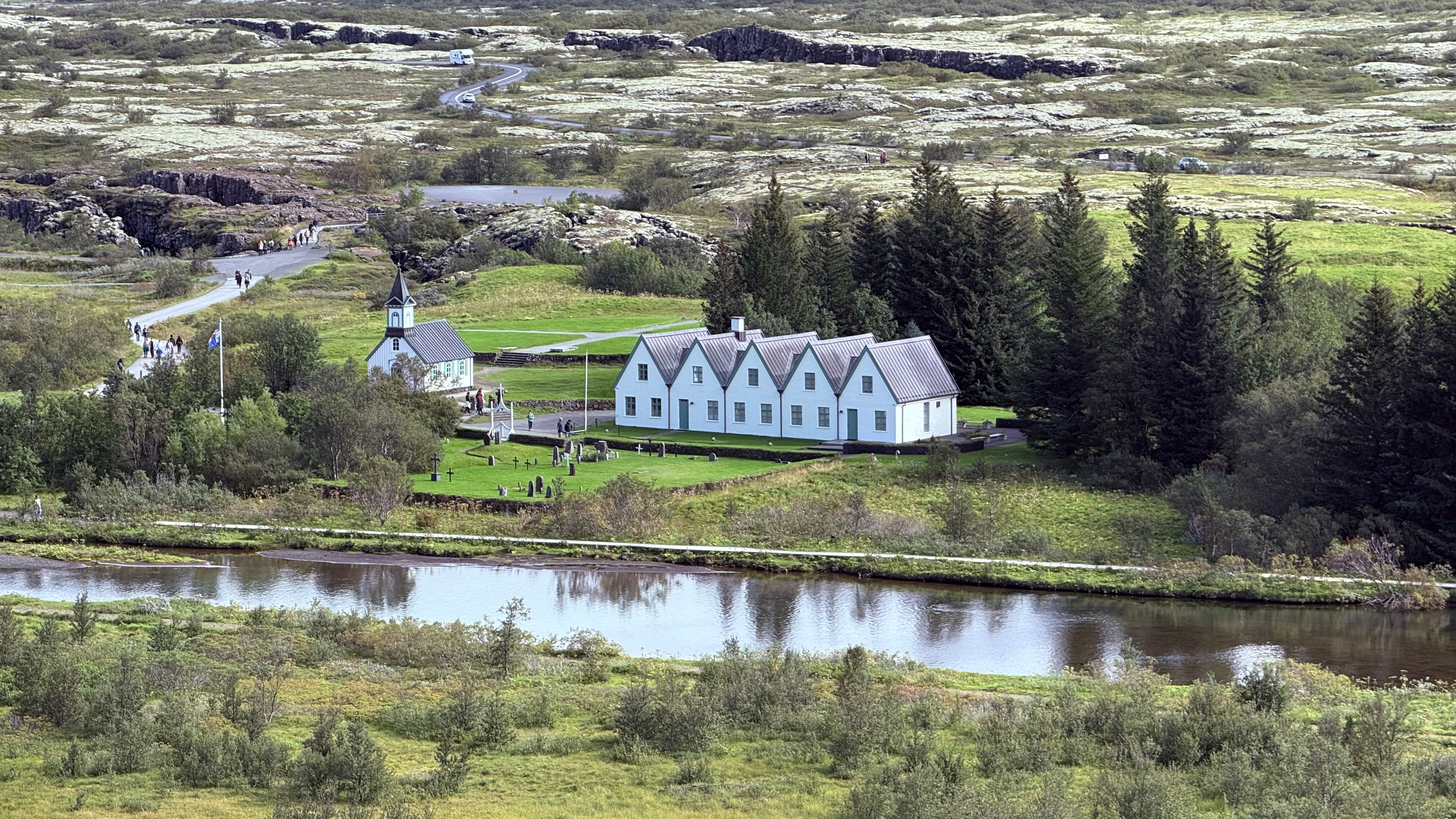 Aerial view of Thingvellir historic buildings beside tectonic fissures and a lake