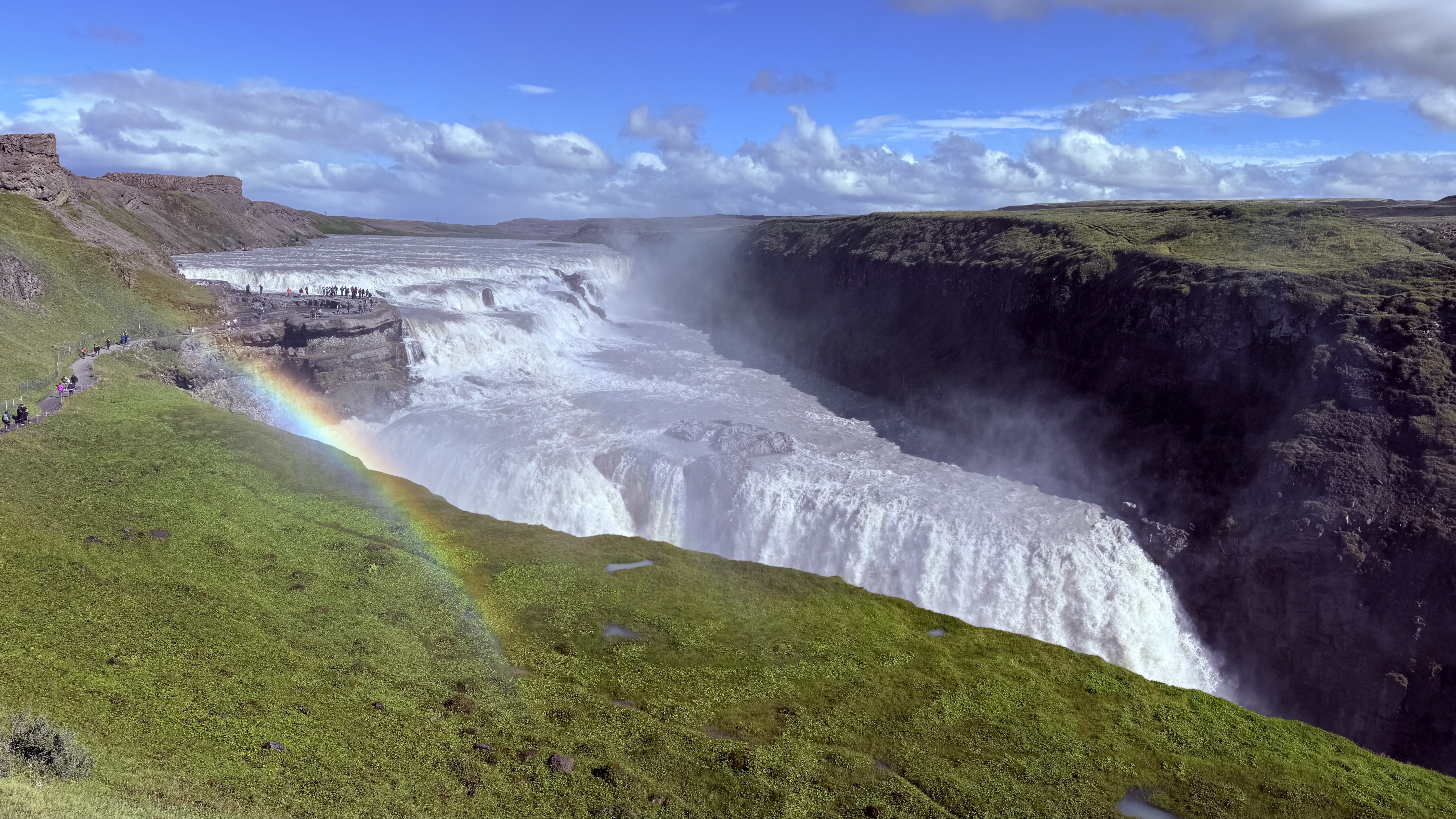 Gullfoss waterfall cascading into a gorge with a rainbow in the mist