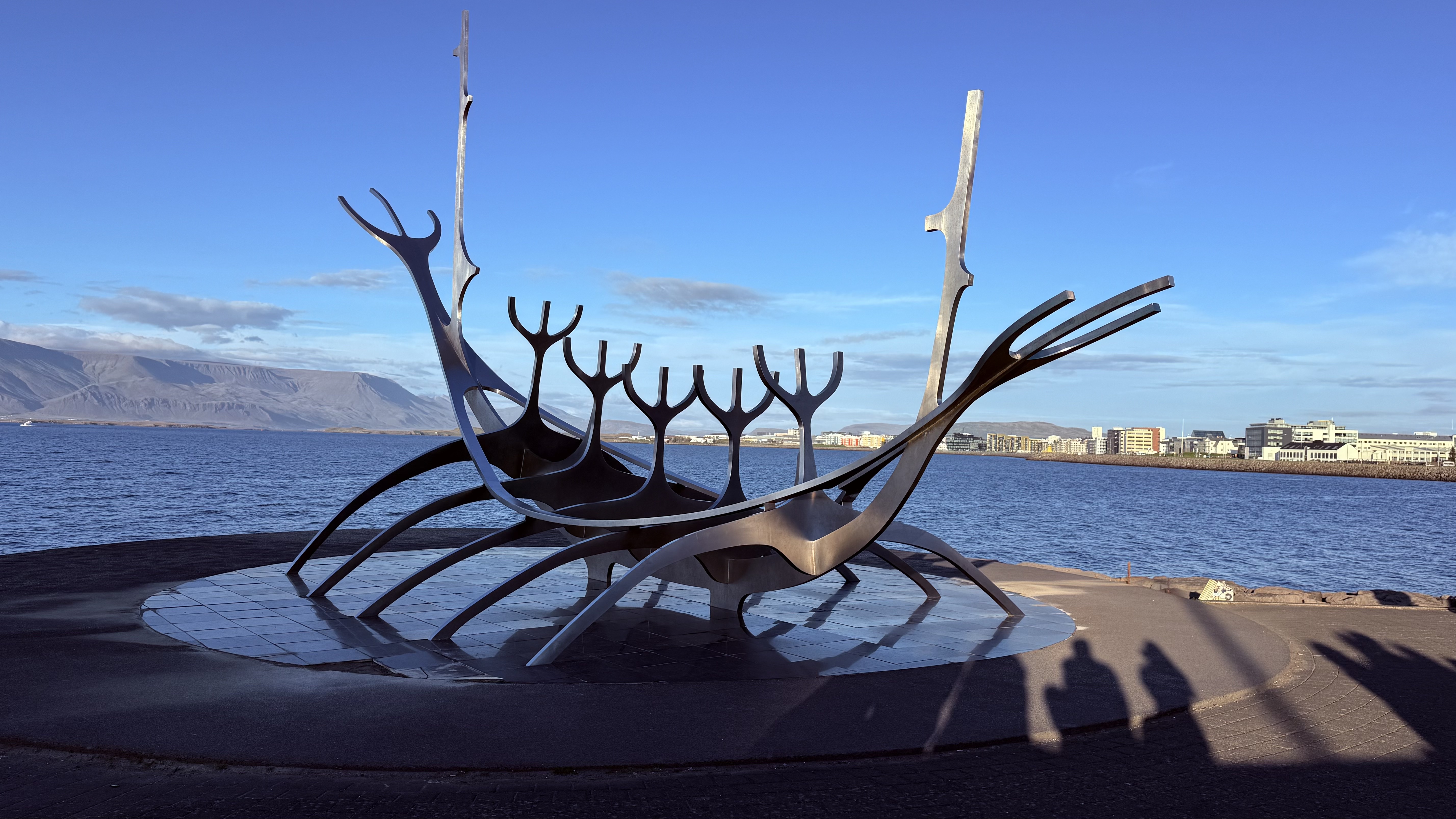 The Sun Voyager steel sculpture silhouetted against a clear sky and mountains