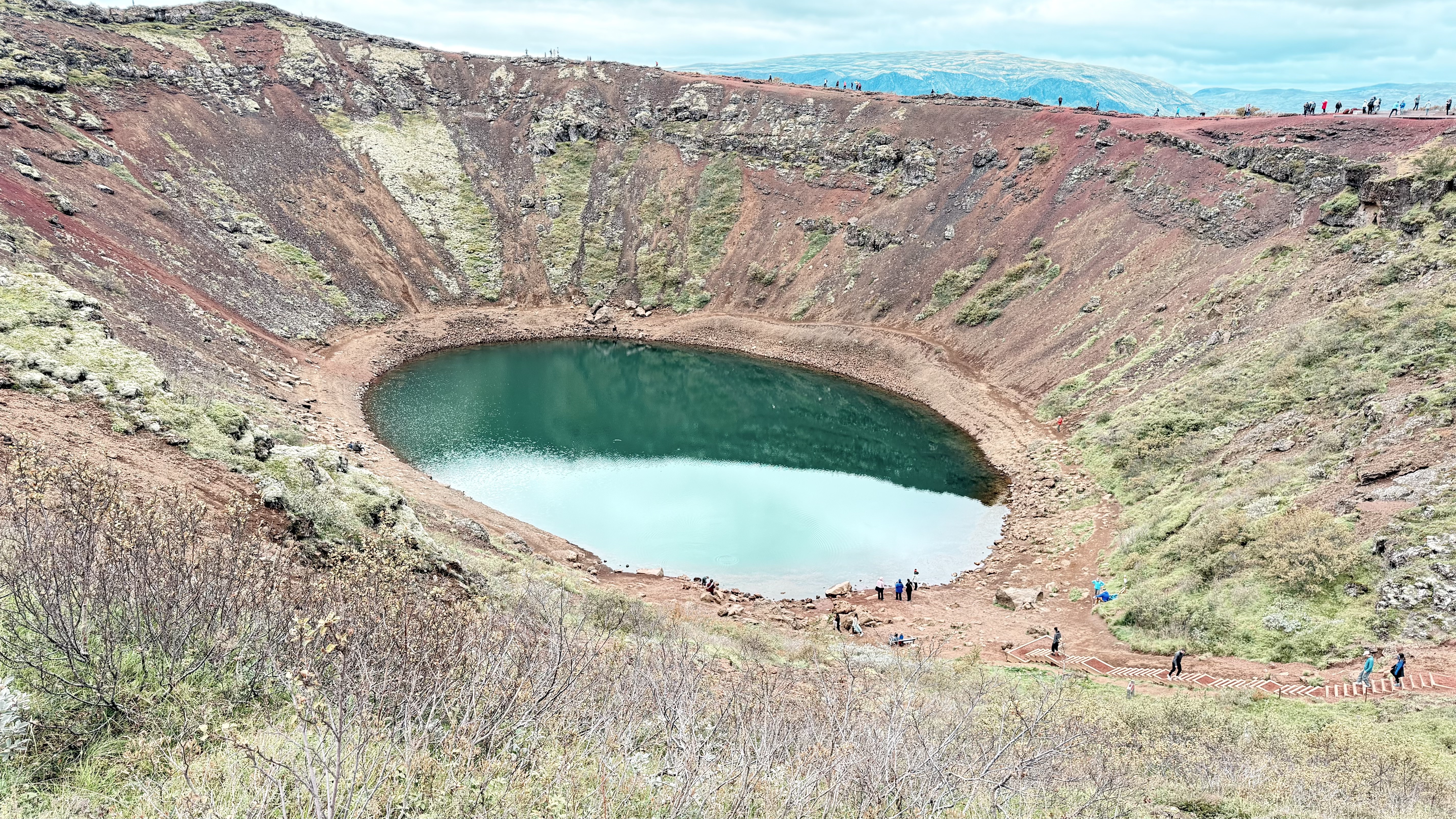Kerid volcanic crater with vivid turquoise lake and red-earth walls
