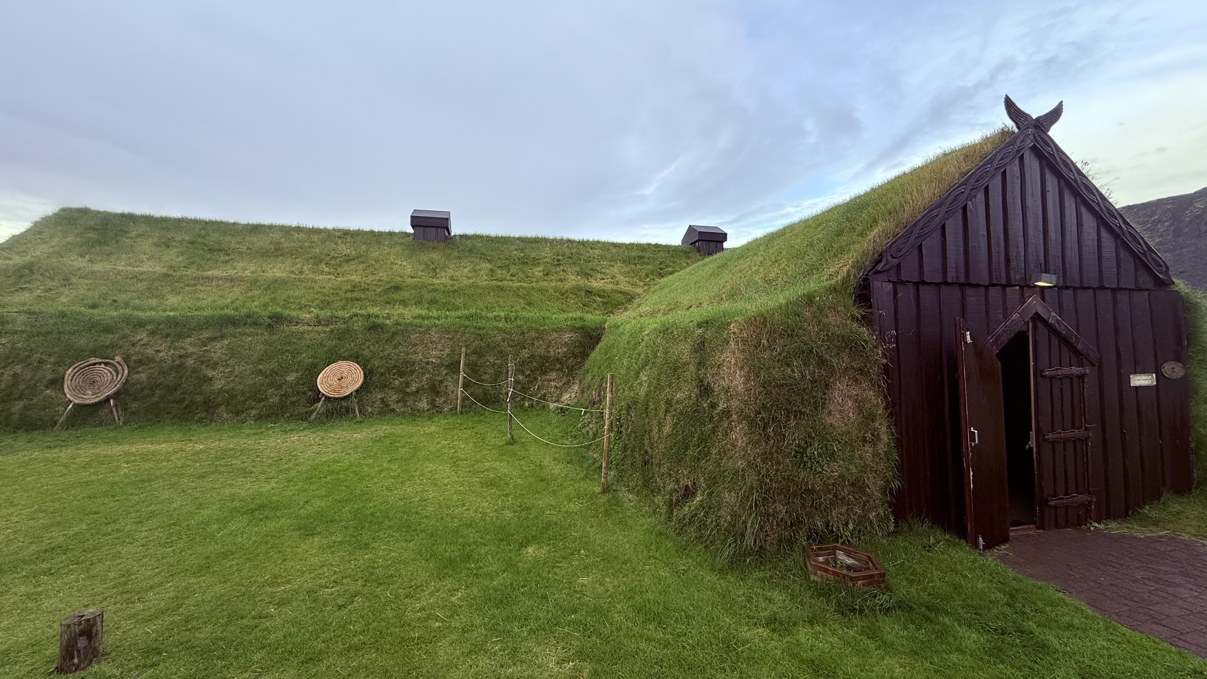 A turf-roofed Viking longhouse with grass growing on top