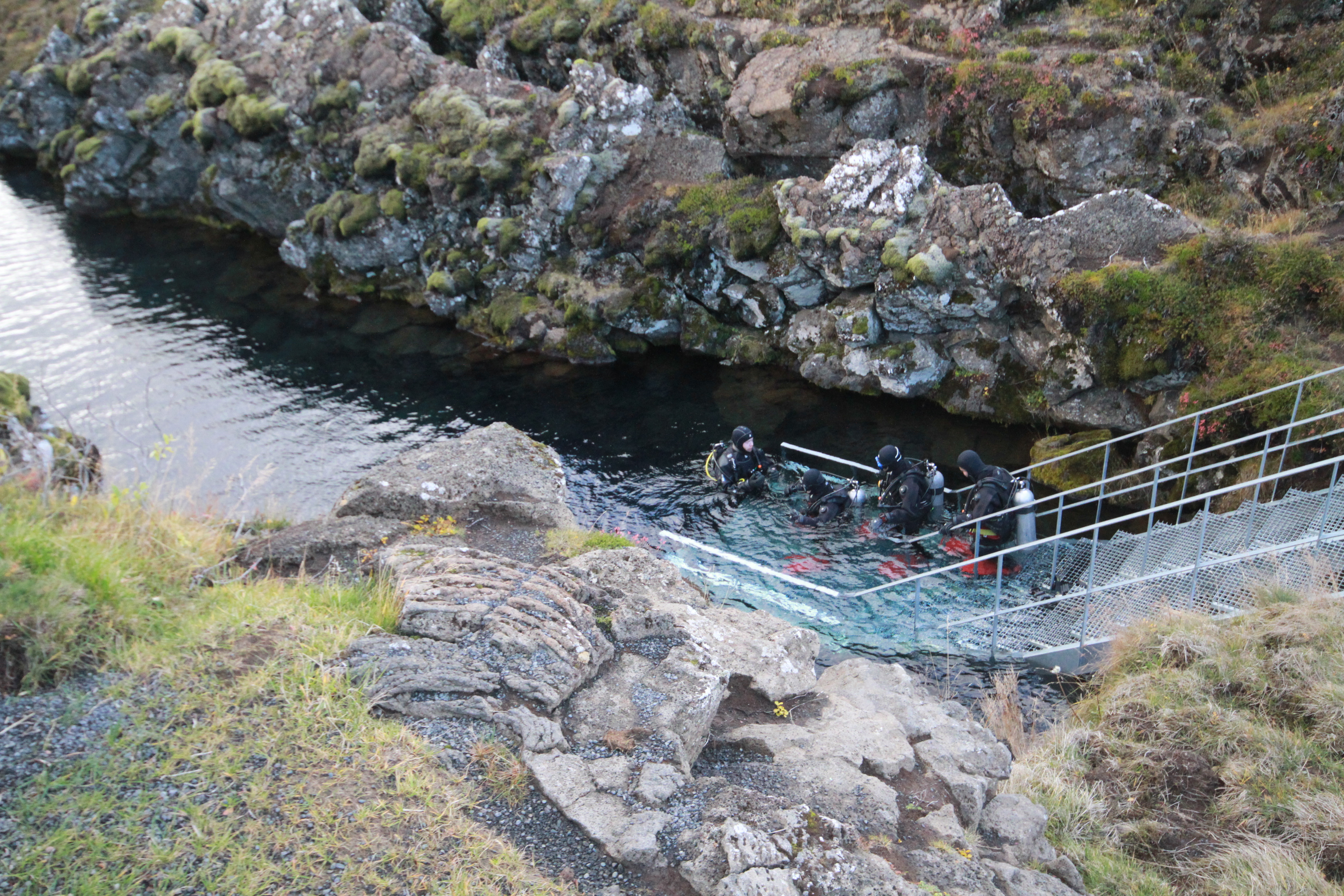 Snorkelers entering Silfra fissure from the metal platform